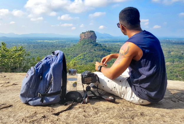 MAN SITTING IN MOUNTAINS